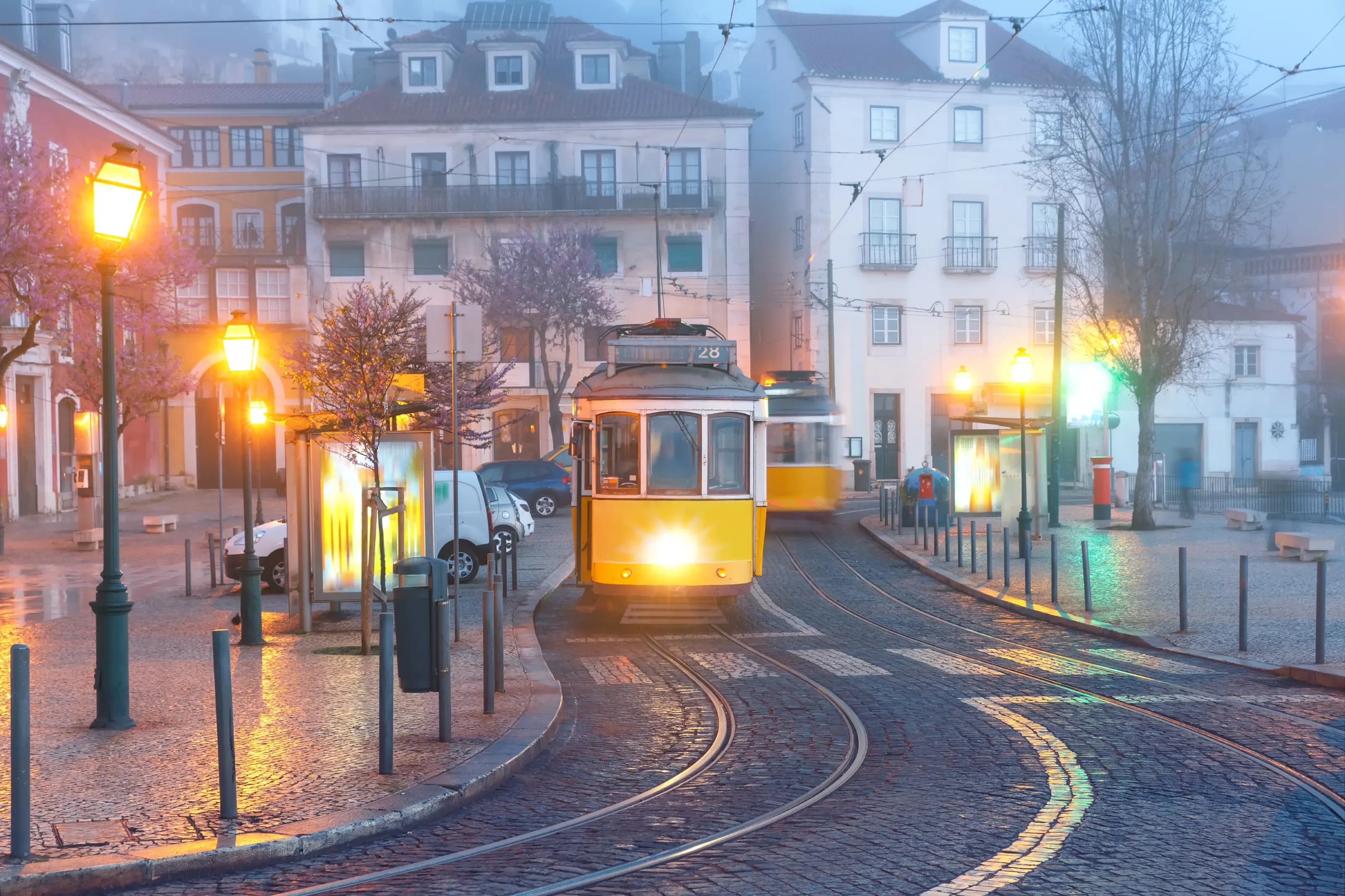 Yellow 28 tram in Alfama, Lisbon, Portugal. Famous vintage yellow 28 tram on street of Alfama, the oldest district of the Old Town, in the foggy morning, Lisbon, Portugal