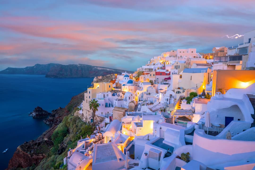 Cityscape of Oia town in Santorini island, Greece. Panoramic view at the sunset